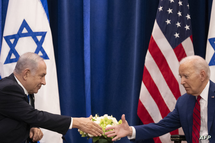 US President Joe Biden shakes hands with Israeli Prime Minister Benjamin Netanyahu as they meet on the sidelines of the 78th…