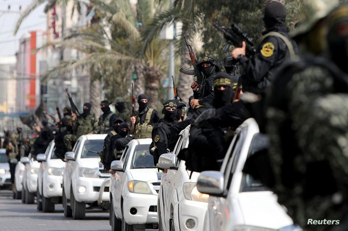 Palestinian Islamic Jihad militants ride on pick up trucks during a symbolic funeral for Ramadan Shallah, a former leader of…