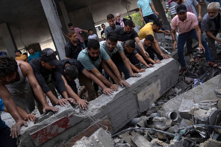 فلسطينيون يبحثون عن ناجين في مبنى دمره القصف الإسرائيلي في مخيم رفح للاجئين في قطاع غزة يوم الثلاثاء، 17 أكتوبر، 2023. (AP Photo/Fatima Shbair)