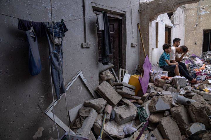 فلسطينيون يجلسون على أنقاض منزل بعد أن قصفته غارة جوية إسرائيلية في خان يونس، جنوب قطاع غزة، الأحد، 29 أكتوبر، 2023. (AP Photo/Fatima Shbair)