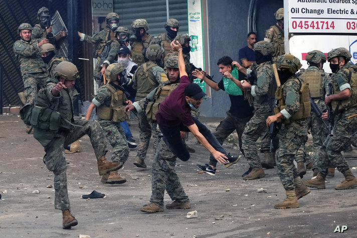 Lebanese army soldiers scuffle with protesters during a demonstration in solidarity with the Palestinian people in Gaza, near…