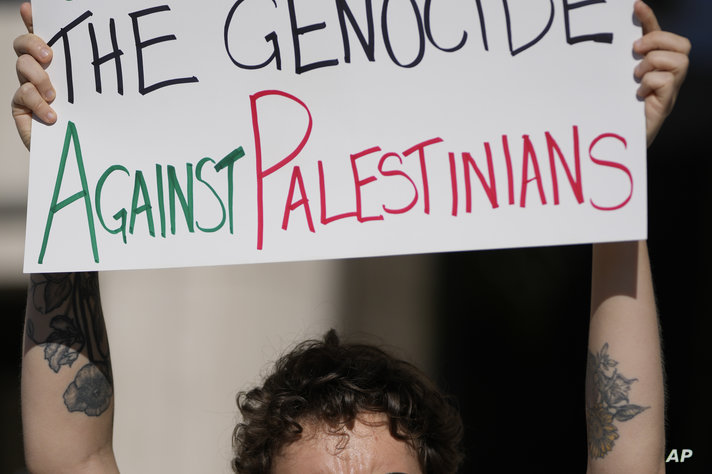 A member of South Florida Jewish Voice for Peace who preferred to be identified only by her first name, Emma, holds a sign…