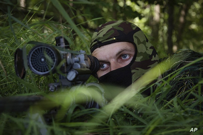 In this photo released by the Russian Defense Ministry Press Service on Thursday, Aug. 10, 2023, a Russian sniper looks from…