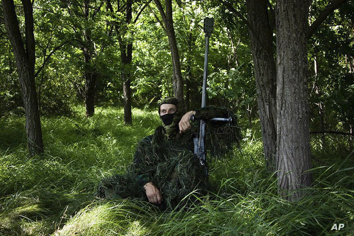 In this photo released by the Russian Defense Ministry Press Service on Thursday, Aug. 10, 2023, a Russian sniper sits at his…