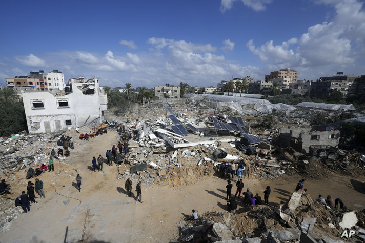 فلسطينيون يبحثون عن ناجين بعد قصف إسرائيلي استهدف منزل عائلة درويش في مخيم النصيرات للاجئين في قطاع غزة