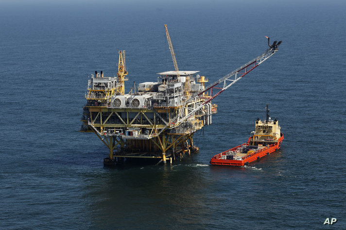 FILE - A rig and supply vessel are viewed in the Gulf of Mexico off the cost of Louisiana, April 10, 2011. A sale of federal…