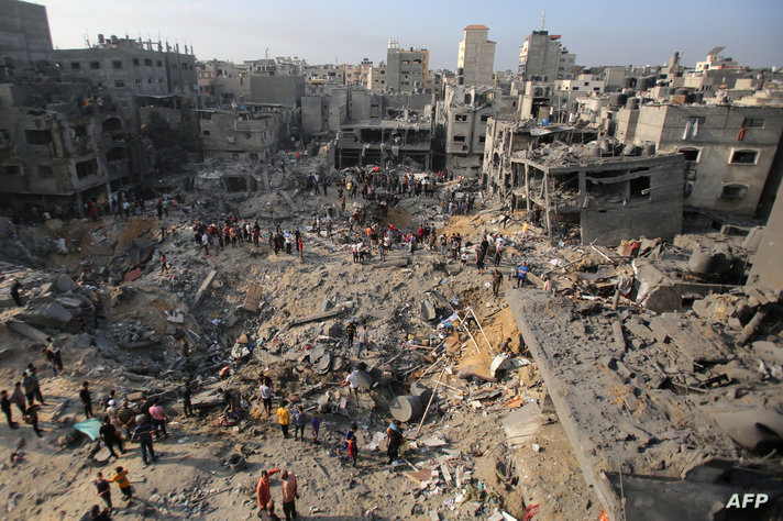 Palestinians check the destruction in the aftermath of an Israeli strike the previous night in the Jabalia camp for Palestinian…