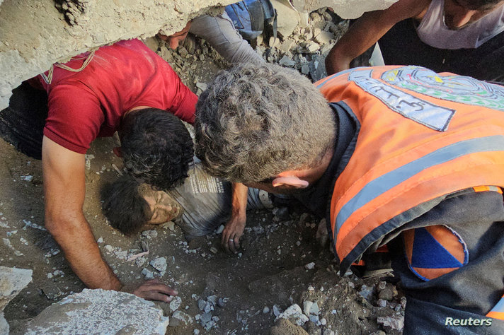 Palestinians search for casualties at the site of Israeli strikes on houses in Jabalia refugee camp