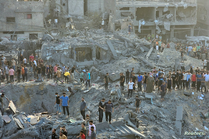 Palestinians search for casualties at the site of Israeli strikes on houses in Jabalia refugee camp