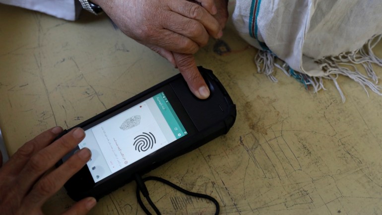 An election official scans a voter's finger with a biometric device at a polling station during a parliamentary election in Kabul, Afghanistan, October 20, 2018. REUTERS/Mohammad Ismail