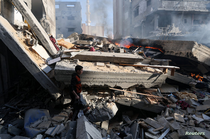 Palestinians inspect a house destroyed in an Israeli strike, in Khan Younis