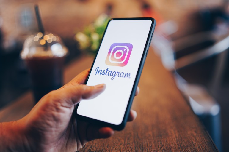 Man holding phone with Instagram application on the screen. Instagram is a popular online social networking service.