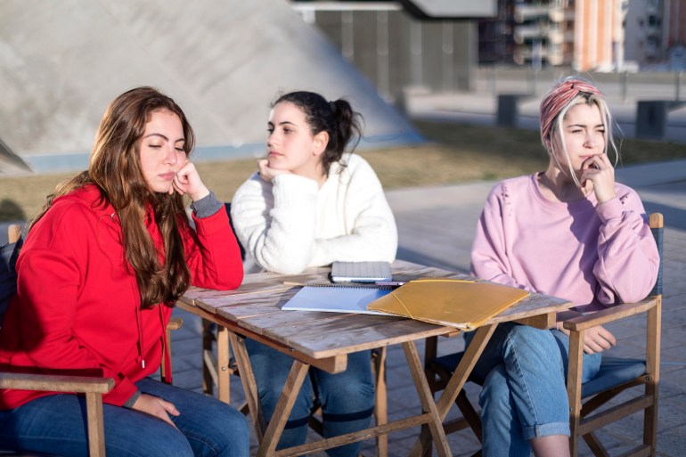 Angry friends or roommates sitting in a cafe outdoors