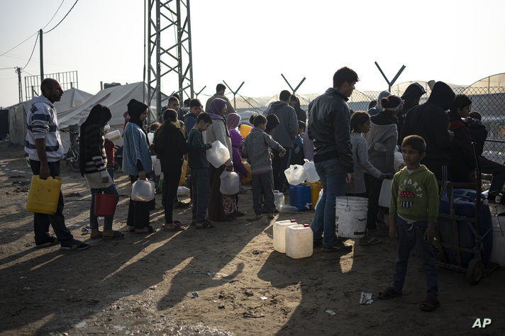 أفراد عائلة أبو جراد ينتظرون كغيرهم من الفلسطينيين النازحين ساعات طويلة للحصول على مياه الشرب 