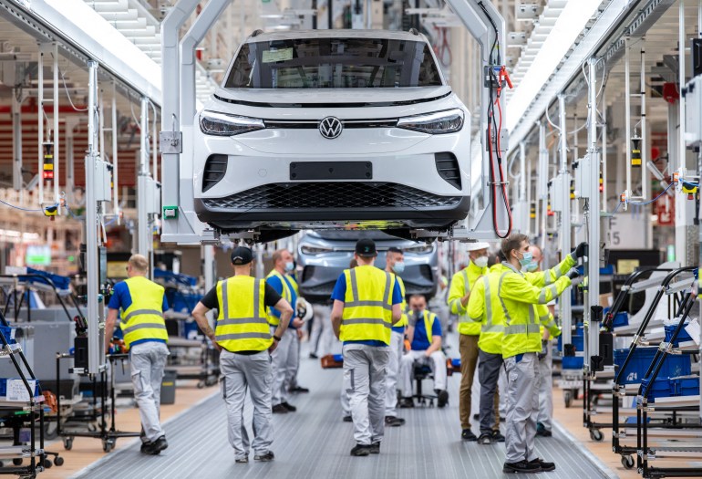 Employees work at the assembly line for the Volkswagen (VW) ID 4 electric car of German carmaker Volkswagen, in the production site of Emden, northern Germany on May 20, 2022. (Photo by DAVID HECKER / AFP)