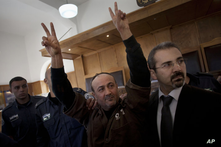 FILE - In this Jan. 25, 2012 file photo, senior Fatah leader Marwan Barghouti makes the victory sign in front of the media…