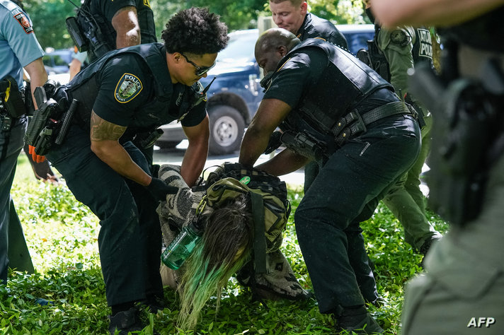 Police officers detain a demonstrator during a pro-Palestinian protest against the war in Gaza at Emory University on April 25,…