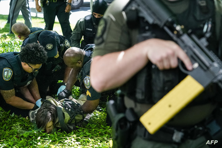 Police officers detain a demonstrator during a pro-Palestinian protest against the war in Gaza at Emory University on April 25,…