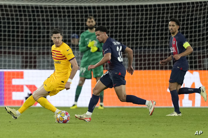 Barcelona's Robert Lewandowski, left, is challenged by PSG's Warren Zaire-Emery during the Champions League quarterfinal first…