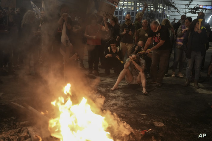 People take part in a protest against Israeli Prime Minister Benjamin Netanyahu's government and call for the release of…