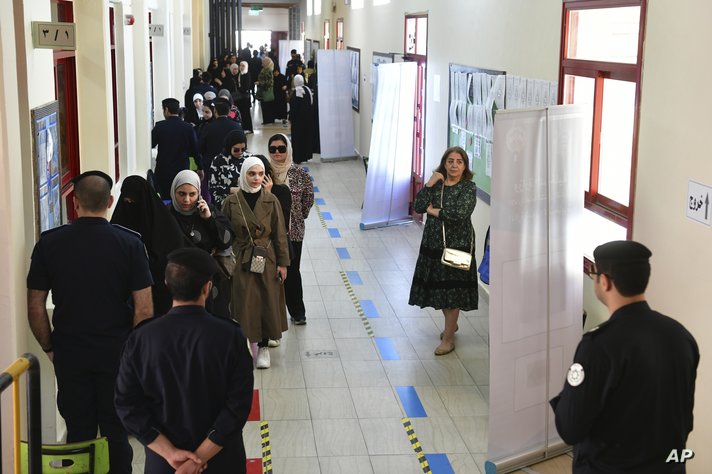 Women queue to cast their votes for the National Assembly elections at Bayan school in Bayan district, Kuwait, Thursday, April…