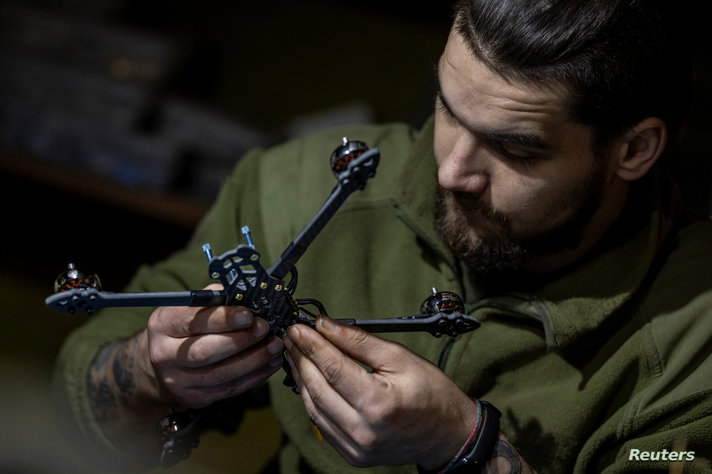 A Ukrainian serviceman of the 58th brigade works on a FPV drone in a workshop in the Donetsk region