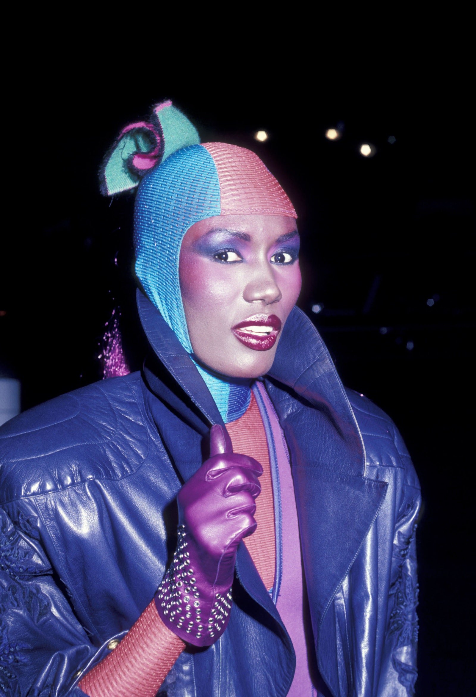 ربما تحتوي الصورة على ملابس Grace Jones، معطف، سترة، وجه، رأس، شخص، تصوير، صورة، قفاز للبالغين، وأرجواني