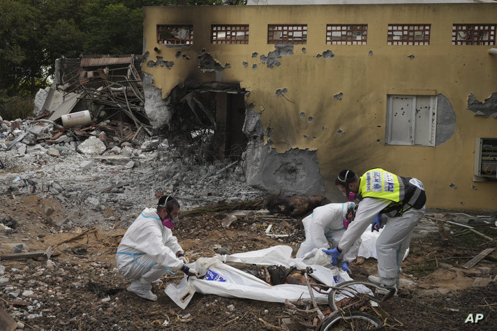 FILE - ZAKA emergency services put the body of a Hamas militant into a body bag in kibbutz Be'eri, Oct. 11, 2023. Some allege…