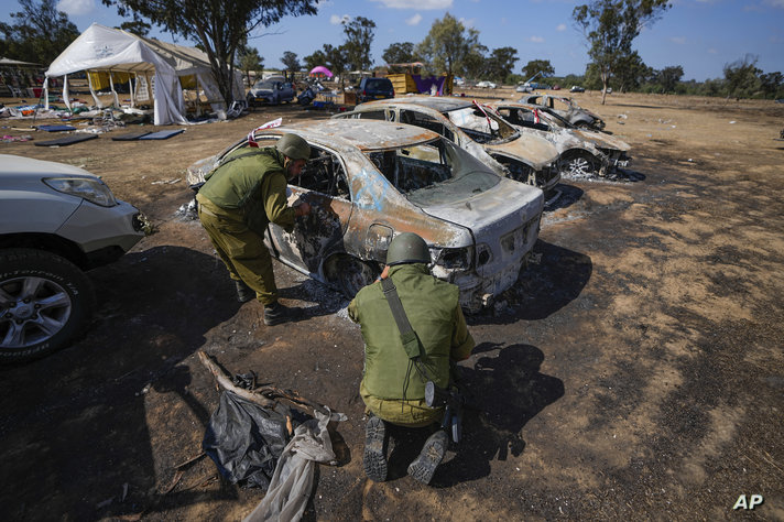 FILE - Israeli soldiers inspect the site of the Nova music festival where at least 260 Israeli festival-goers were killed…