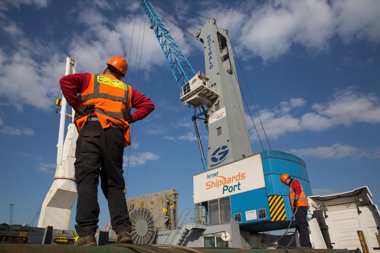 Workers load trucks at Israel Shipyards Port in Haifa February 5, 2014. Three years after Syria plunged into violence, Israel is reaping an unlikely economic benefit. Exports from Turkey have begun to flow through Israel and across the Sheikh Hussein Bridge to Jordan and a few Arab neighbours. The trade is growing enough to encourage long-held Israeli hopes that the Jewish state can become a commercial gateway to the Arab world. Picture taken February 5, 2014. To match Insight ISRAEL-TRADE/ REUTERS/Baz Ratner (ISRAEL - Tags: BUSINESS POLITICS TRANSPORT MARITIME)