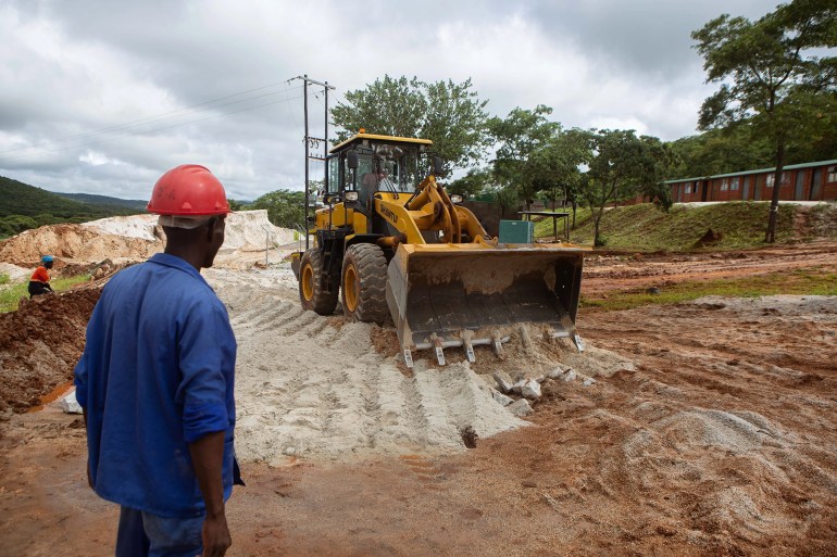 A foreman looks on as a bulldozer works on the slippery road at Arcadia lithium mine [File: Tafadzwa Ufumeli/Getty Images]