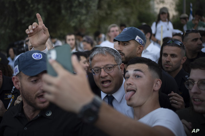 An Israeli takes a selfie with the Israel's National Security Minister Itamar Ben-Gvir, center, as he arrives at the Damascus…