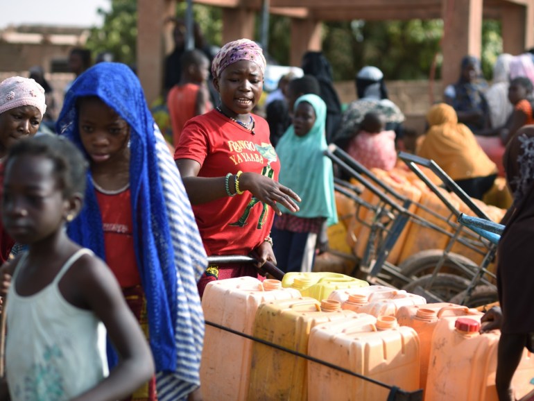 People wait for their turn to buy water from a privately-owned water tower, amid an outbreak of the coronavirus disease (COVID-19), in Taabtenga district of Ouagadougou, Burkina Faso April 3, 2020. Picture taken April 3, 2020. REUTERS/Anne Mimault