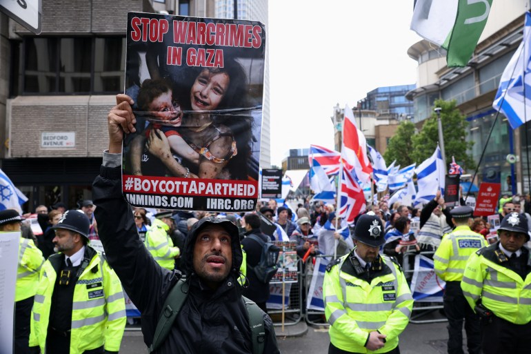 SENSITIVE MATERIAL. THIS IMAGE MAY OFFEND OR DISTURB A man holds up a placard during a pro-Palestinian demonstration outside Barclays Bank, amid the ongoing conflict between Israel and the Palestinian Islamist group Hamas, in London, Britain, April 20, 2024. REUTERS/Hollie Adams