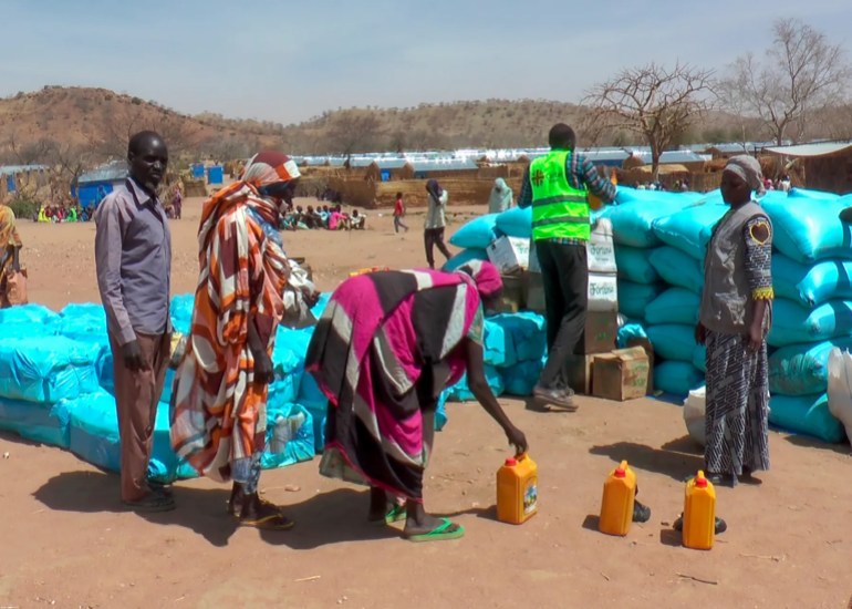 Refugees displaced by the war in Sudan receive food from aid agencies at the Metche camp in eastern Chad [File: Jsarh Ngarndey Ulrish/AP]