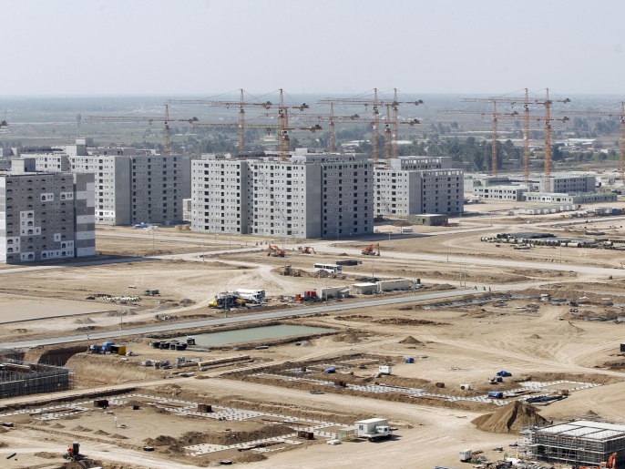 A general view of Bismayah residential project in Baghdad, February 26, 2015. On a main highway south of Baghdad, dozens of buildings rise up from the Iraqi plains, the first blocks of a multi-billion-dollar city emerging from a landscape more accustomed to conflict and crisis than glitzy new development. Bismayah New City, which aims to house half a million people within four years, dwarfs any construction project Iraq has attempted in a generation. Picture taken February 26, 2015. REUTERS/Thaier Al-Sudani (IRAQ - Tags - Tags: POLITICS BUSINESS REAL ESTATE)