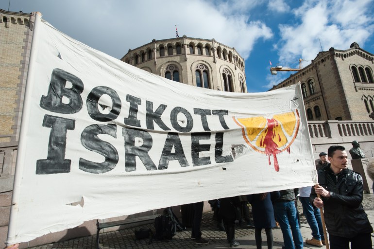 OSLO - MARCH 30: Solidarity activists hold a banner reading "Boycott Israel" during a protest in front of the Norwegian Parliament building, Stortinget, Oslo, March 30, 2015.