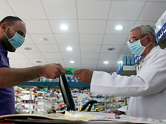 A man, wearing a surgical mask as a precautionary measure against the novel coronavirus, pays for medicine at a hospital pharmacy in Khobar city in Dammam May 21, 2013. Saudi Arabia has reported another case of infection in a concentrated outbreak of a new strain of a virus that emerged in the Middle East last year and spread into Europe, the World Health Organization (WHO) said on May 18, 2013. In a disease outbreak update issued from its Geneva headquarters, the WHO said the latest patient is an 81-year-old woman with multiple medical conditions. She became ill on April 28 and is in a critical but stable condition. Worldwide, there have now been 41 laboratory-confirmed infections, including 20 deaths, since the new coronavirus was identified by scientists in September 2012. REUTERS/Stringer (SAUDI ARABIA - Tags: HEALTH SOCIETY)