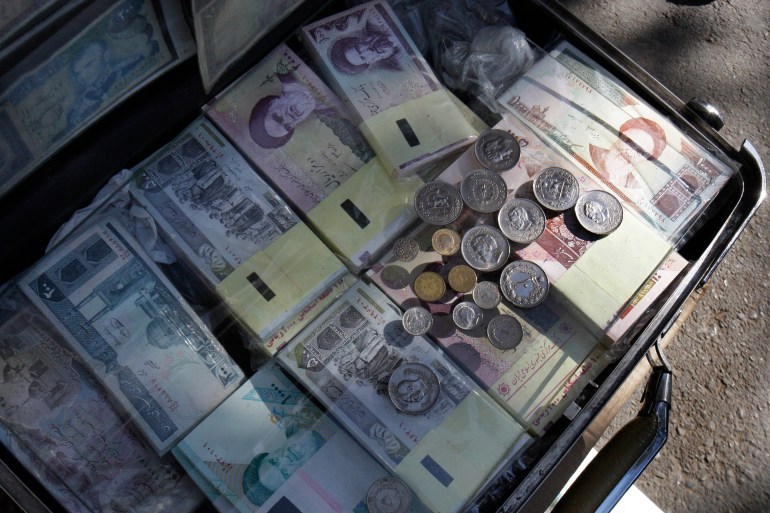 In this photo taken on Wednesday, Oct. 24, 2012, current and pre-revolution Iranian banknotes and coins are displayed by a vendor at the Ferdowsi Street in Tehran, Iran. Iranian authorities have been forced to quell protests in recent weeks over the plummeting value of the country's currency which lost nearly 40 percent of its value against the U.S. dollar in a week in early October. With the U.S. election less than 10 days away, both President Obama and Republican challenger Mitt Romney are cautious about discussing potential compromises as Iran's economy shows signs of increasing strain from economic sanctions that seek nuclear concessions. (AP Photo/Vahid Salemi)