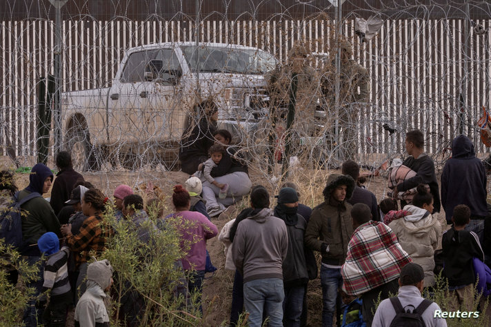 FILE PHOTO: Migrants are halted by Army National Guard after breaching razor wire fence in El Paso