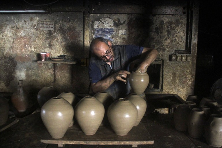 A person works in a pottery workshop as Palestinians respond to an increase in the demand for clay pots used to cool water due to power cuts and hot weather, according to workers, amid the Israel-Hamas conflict, in Gaza City August 13, 2024. REUTERS/Mahmoud Issa