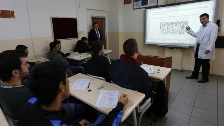 A teacher points to the board as he teaches students during a biology class at FEM University Preparation School in Uskudar November 27, 2013. Turkish leader Tayyip Erdogan, shaken by a graft scandal he says is concocted by a former ally, is fighting to secure his political future in the run up to March polls. But more than that, he sees at stake the legacy of an 11-year drive to reshape Turkey, breaking the hold of a secular, urban elite. Picture taken November 27, 2013. To match Insight TURKEY-ERDOGAN/ REUTERS/Murad Sezer (TURKEY - Tags: POLITICS RELIGION EDUCATION)