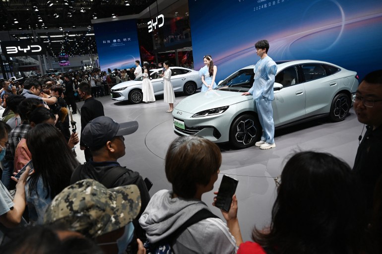 Crowds gather to view BYD electric cars on the BYD stand at the Beijing Auto Show in Beijing on May 3, 2024. (Photo by GREG BAKER / AFP)