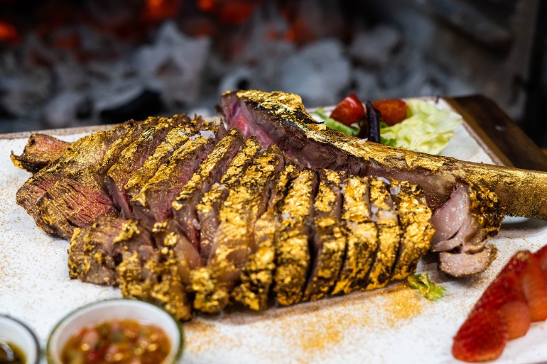 Premium beef tomahawk coated in edible gold