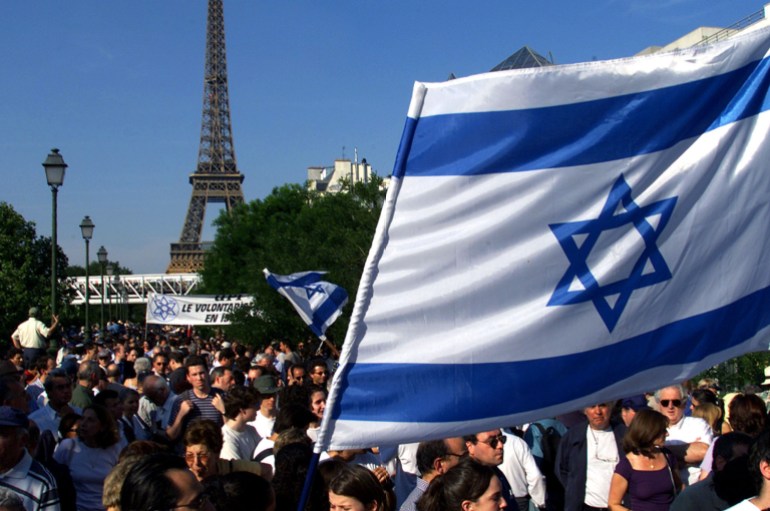 French Jewish groups crowd near the Eiffel Tower with Israeli flags during a protest demonstration against the visit to France by Syria's President [Bashar al-Assad], in Paris, June 25, 2001. [Syrian President Bashar al-Assad starts his June 25-27 visit under pressure to rebuild his international image which was tarnished by remarks about Jews. ]