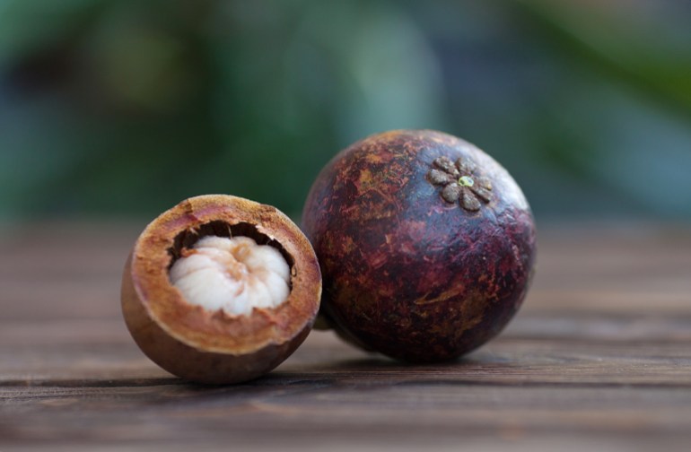 Purple mangosteen or Garcinia Mangostana, known simply as Mangosteen. Wooden background.