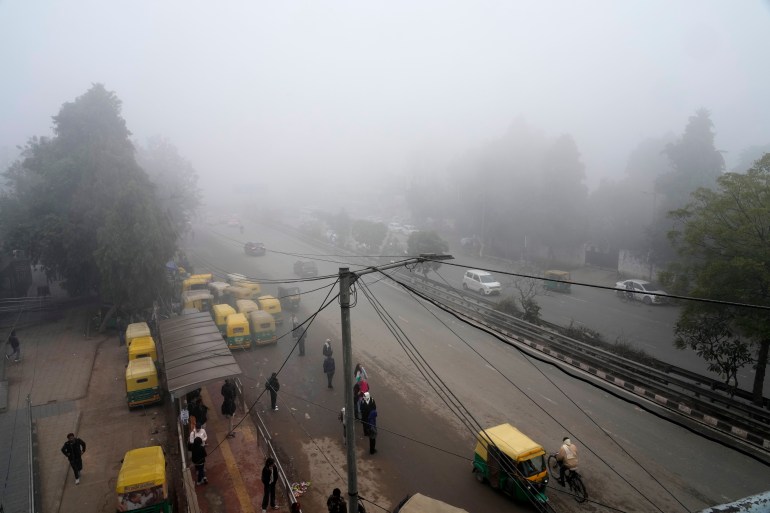 People wait at a bus stop amidst dense fog and cold wave in New Delhi, India, Saturday, Jan. 4, 2025. (AP Photo/Manish Swarup)