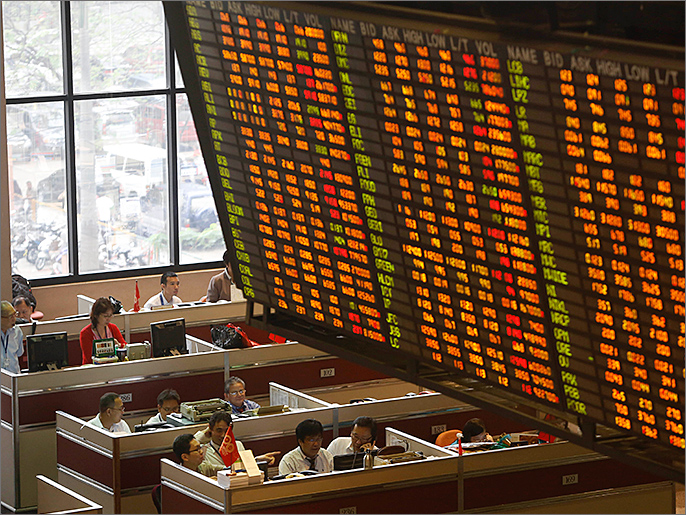 epa03601165 Filipino traders work at their stations as an electronic board with stocks figures is seen above at the Philippine Stock Exchange (PSE) Center in Pasig City, east of Manila, Philippines 26 February 2013. The PSE index closed at 6,630.67 on 26 February, dropping 90.66 points or 1.35 percent from its close of 6,721.33 the day before. Local business news reports stated analysts cited that there were investor concerns related to developments in the Italy electioins that had an effect on US markets and emerging markets. EPA/ROLEX DELA PENA