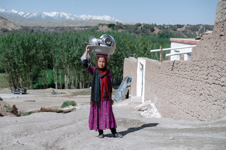 Afghan ethnic Hazara girl carries dishes washed in murky water canal. Recent ongoing droughts decrease the water availability which increases girls' workload as primary collectors of water.01.05.2019