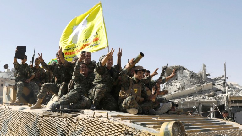 Syrian Democratic Forces (SDF) fighters ride atop of military vehicle as they celebrate victory in Raqqa, Syria, October 17, 2017. REUTERS/Erik De Castro